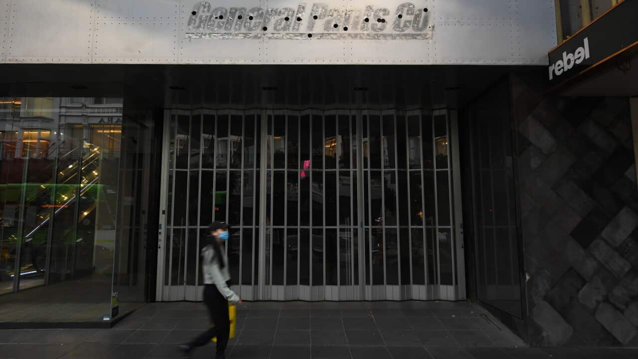 Una passante davanti ad un negozio chiuso di Melbourne.