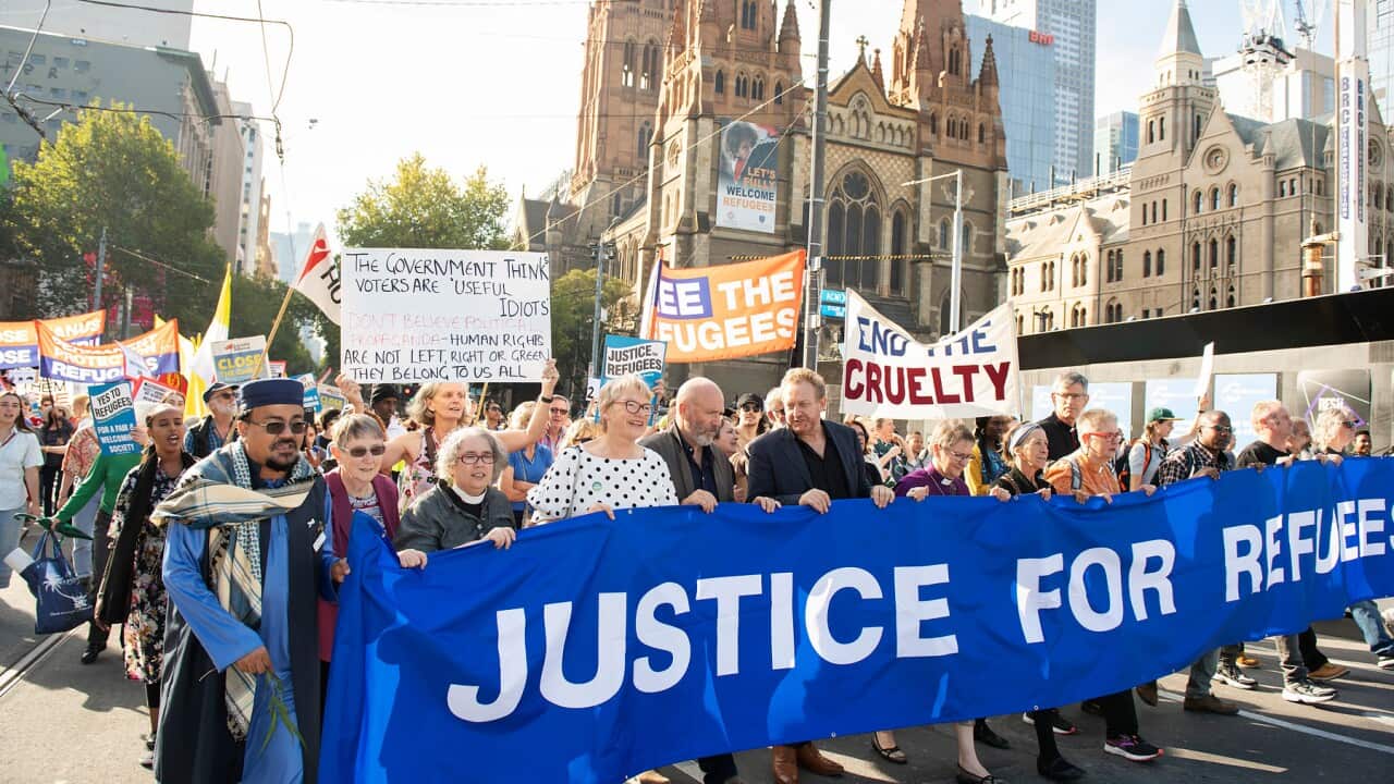 Refugee advocates march down Swanston Street during a Palm Sunday Rally for refugees outside the State Library in Melbourne, Sunday, April 14, 2019. (AAP Image/Ellen Smith) NO ARCHIVING