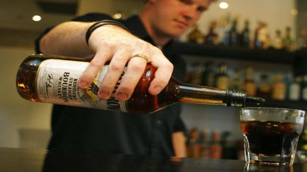 Barman pouring alcohol into a glass