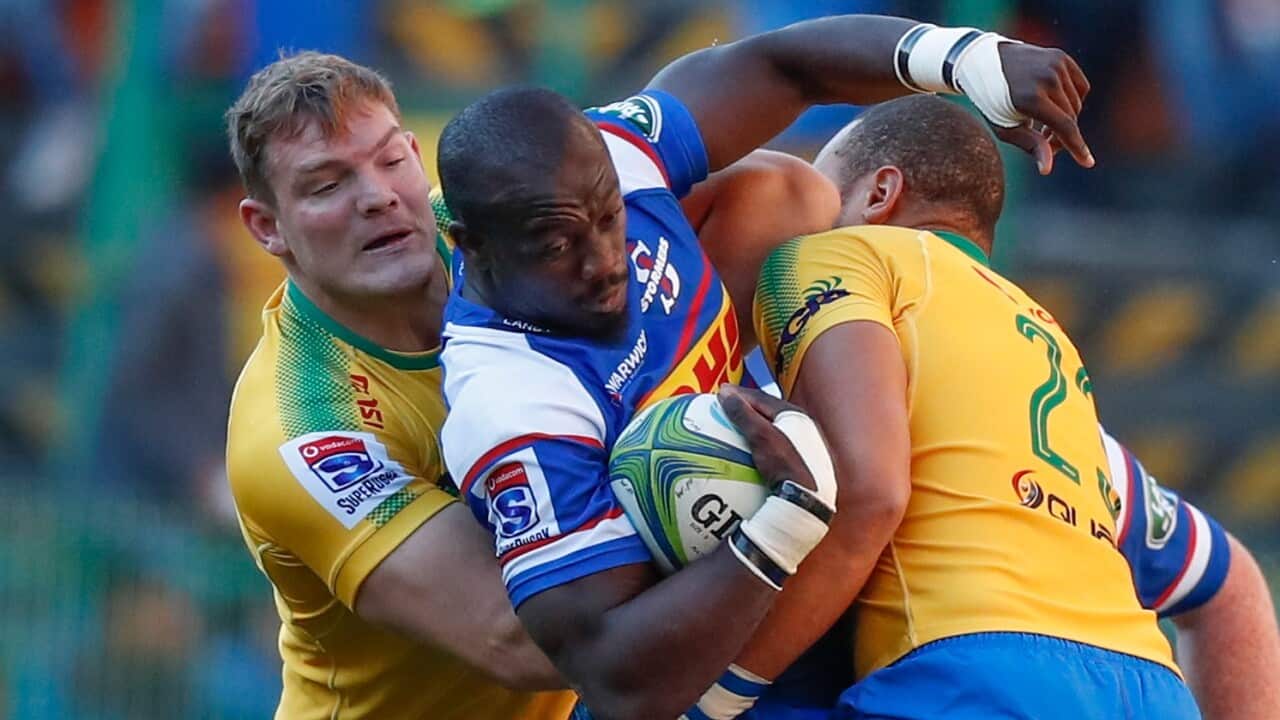 Raymond Rhule (C) from the Stormers is tackled by Travis Ismaiel (R) and Roelof Smit (L) from the Bulls during the Super Rugby match