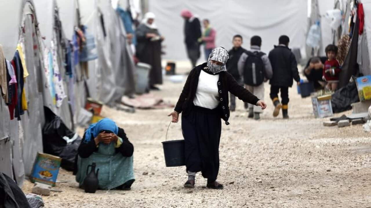 Syrian refugees in front of their tents at a refugee camp