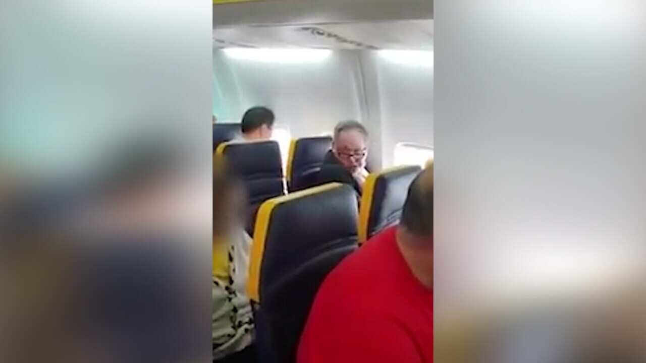 A screenshot from a video that captured a man hurling racial abuse at an elderly woman on a Ryanair flight.