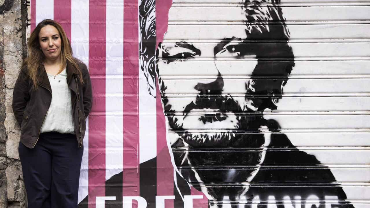 Stella Moris, wife of Julian Assange, near the giant banner