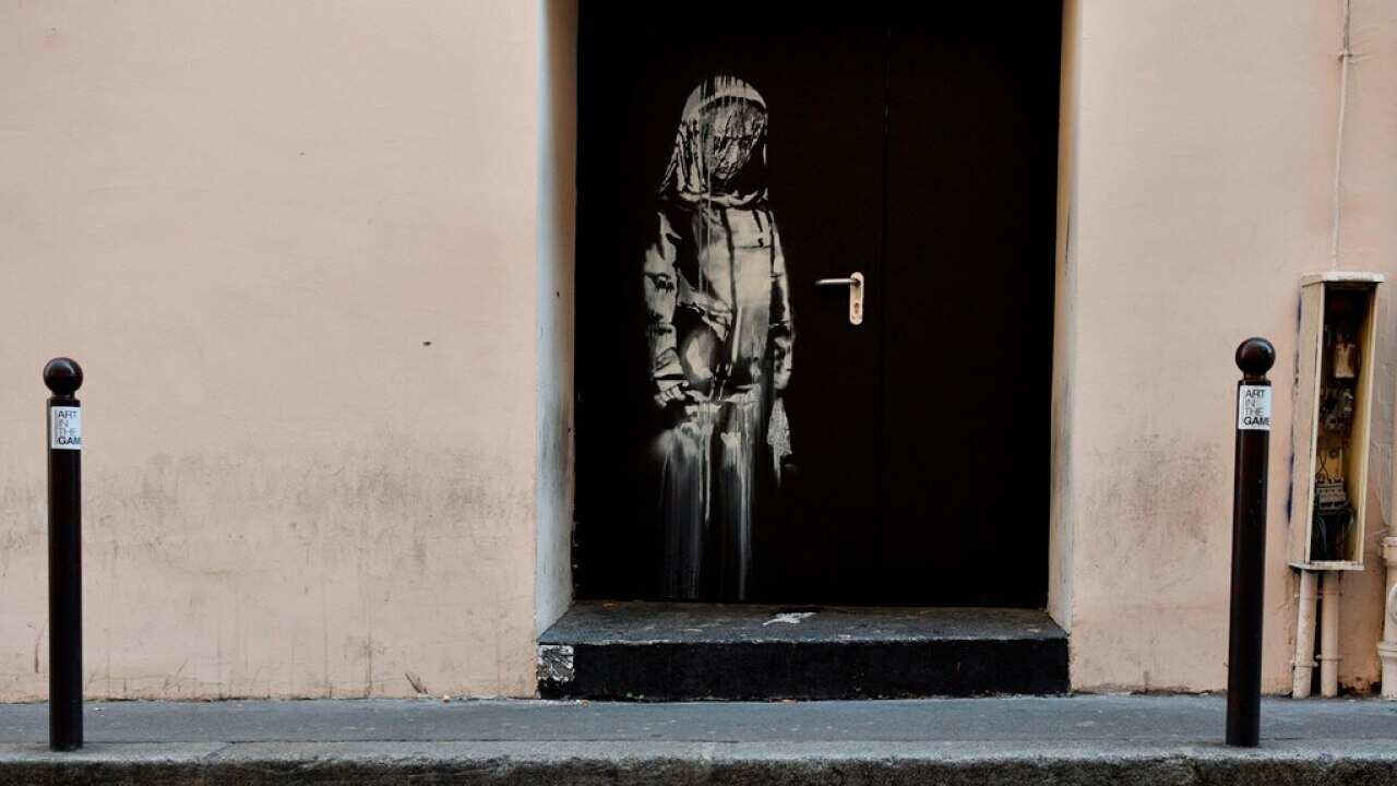 An artwork believed to be attributed to Banksy is of a woman veiled in mourning next to the Bataclan concert venue in Paris