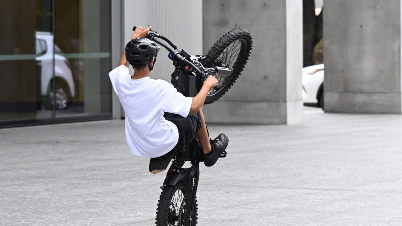 A person riding an e-bike performs a “wheelie“