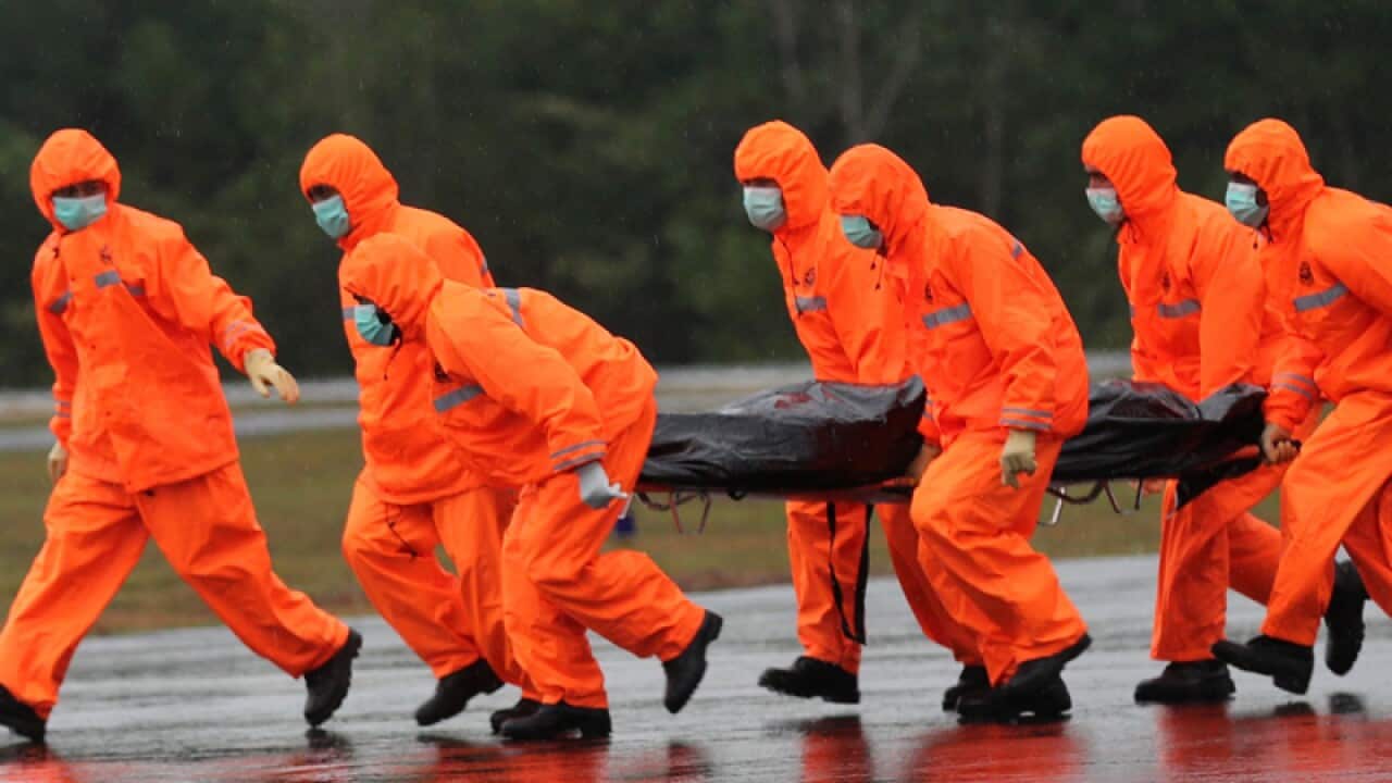National Search and Rescue Agency personnel carry the body of a victim