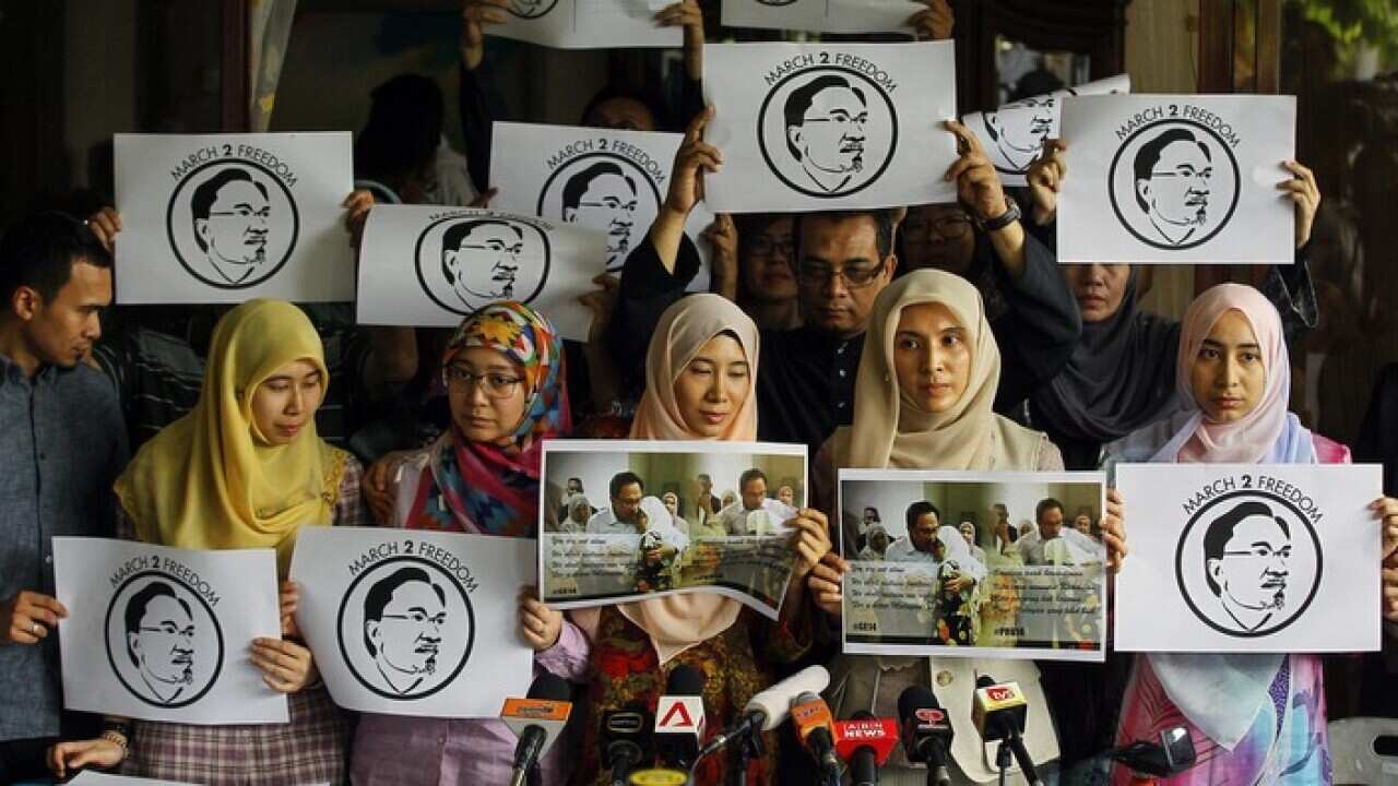 Family members of Malaysian opposition leader Anwar Ibrahim hold placards