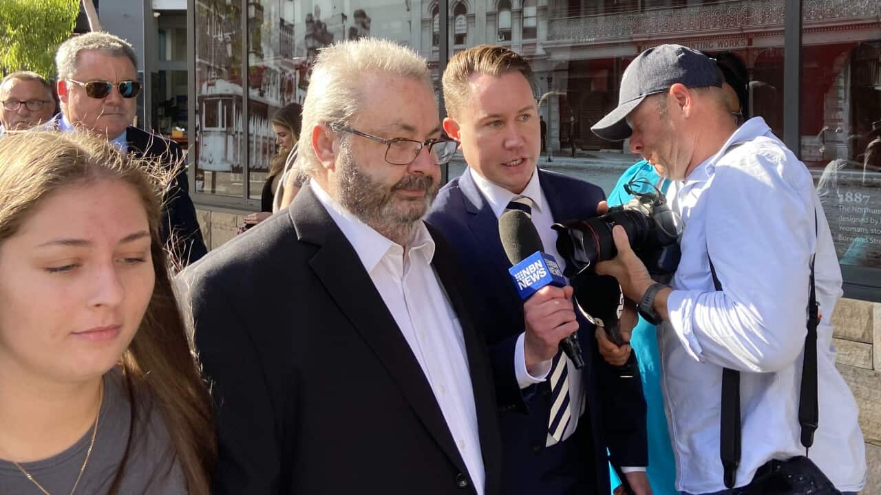 A man in a suit arrives at a court.
