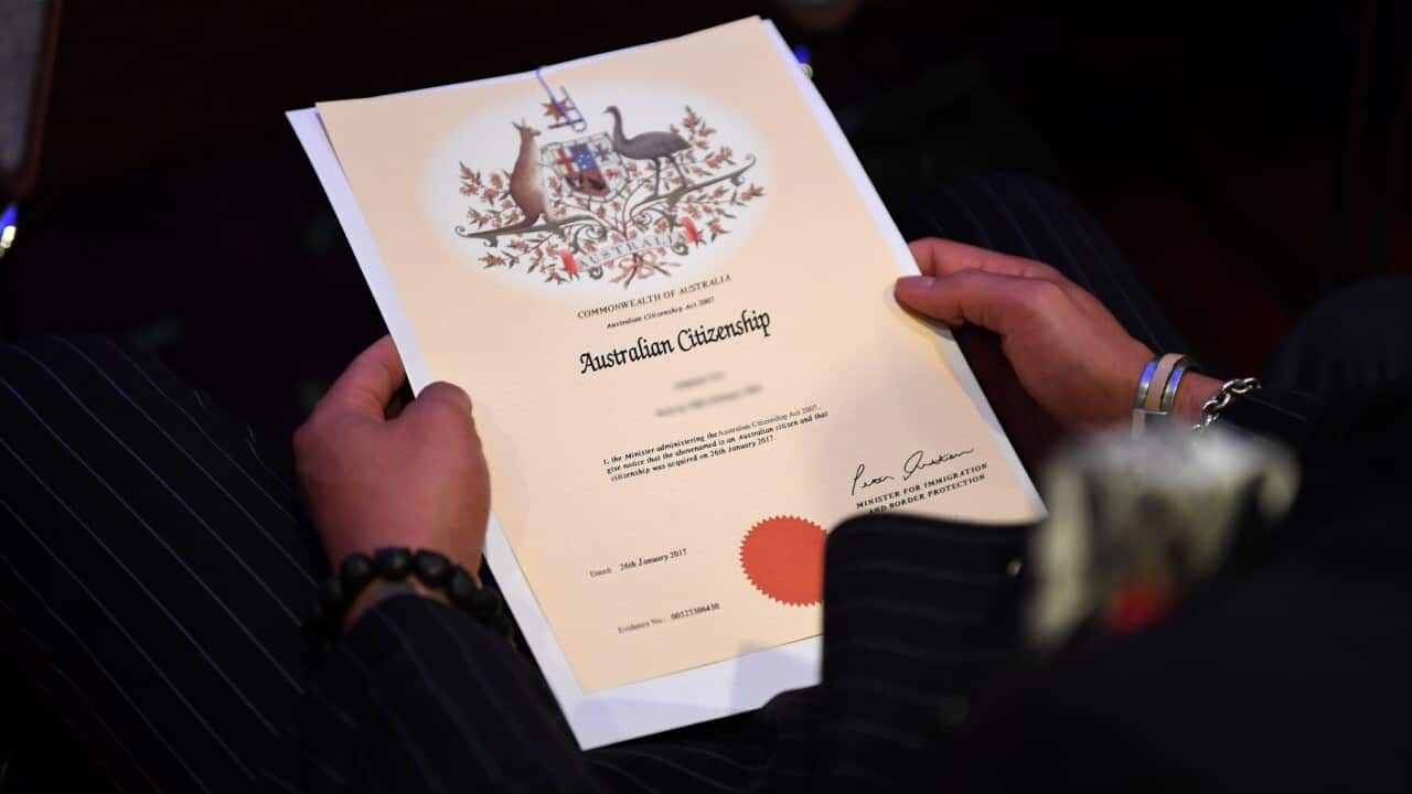 An Australian citizenship recipient holds his certificate during a citizenship ceremony on Australia Day in Brisbane, Thursday, Jan. 26, 2017. (AAP Image/Dan Peled) NO ARCHIVING