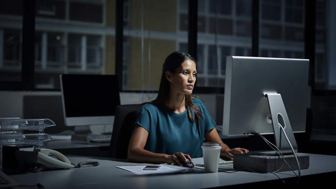 Businesswoman using computer in dark office