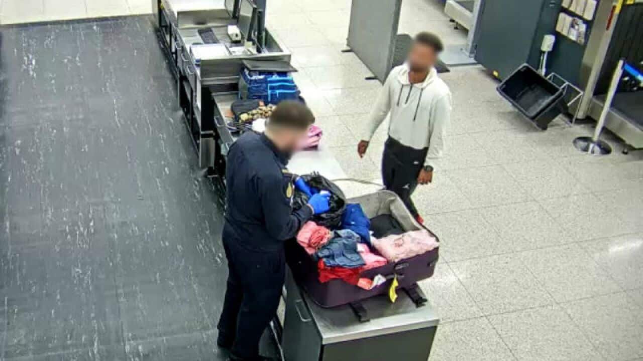 An ABF officer searching the Indian man's baggage soon after his arrival at Perth Airport