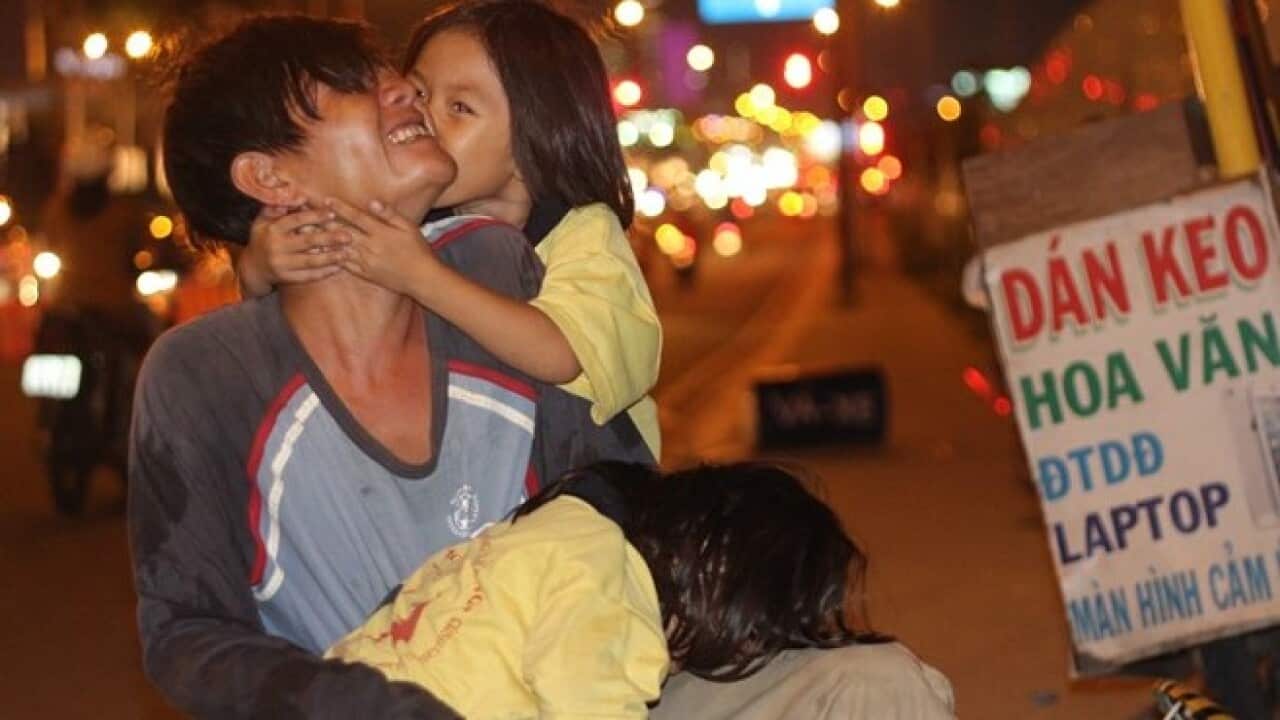 Cha và hai con gái nhỏ trên vỉa hè mưu sinh