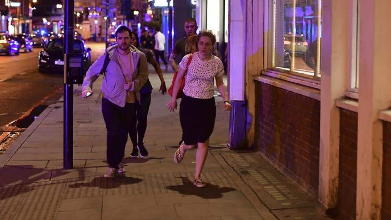 People run down Borough High Street as police are dealing with a "major incident" at London Bridge in London, Saturday, June 3, 2017.  London incident. (Dominic Lipinski/PA via AP)