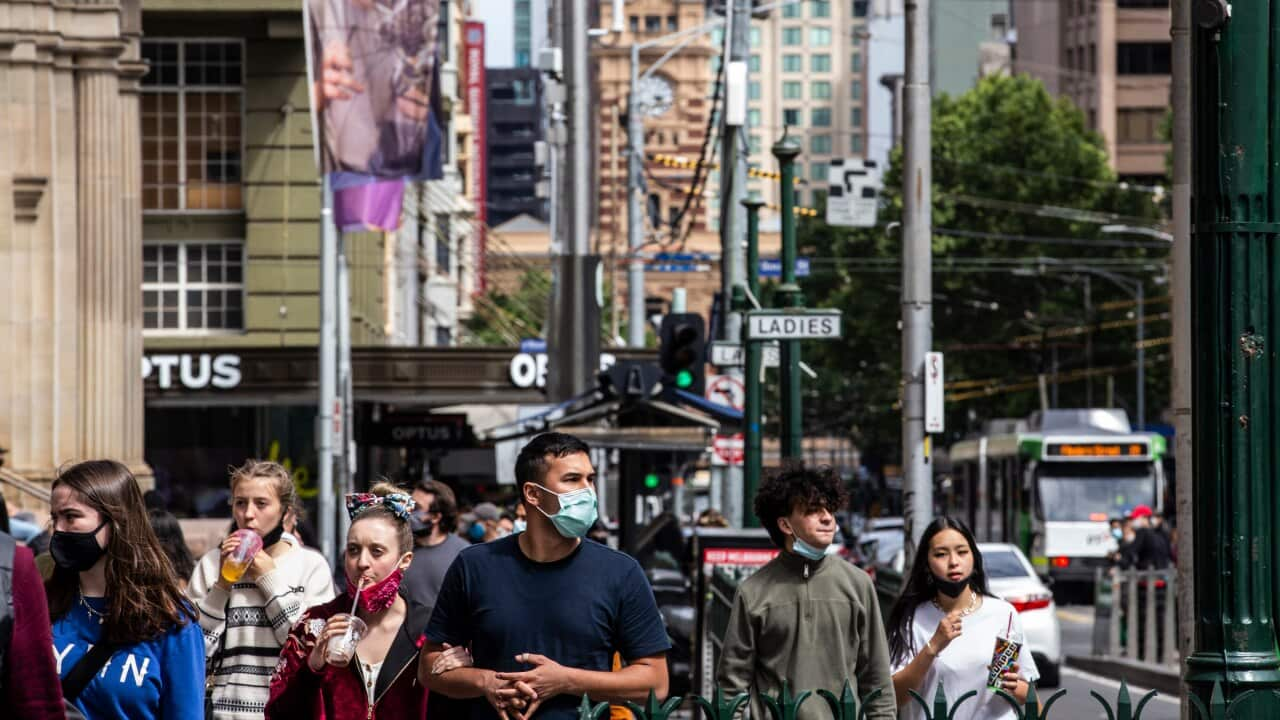 People wearing face masks are seen walking down Melbourne's Elizabeth Street.