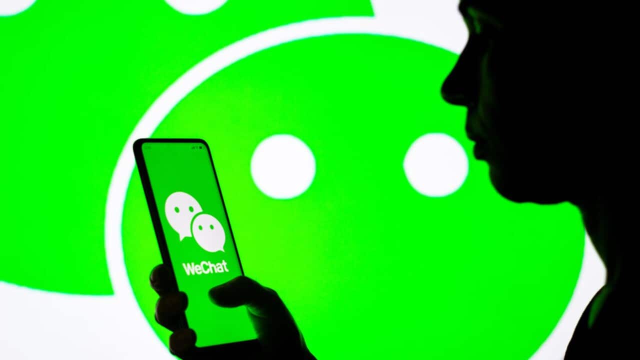 A woman holds a photo with the WeChat logo (Getty).