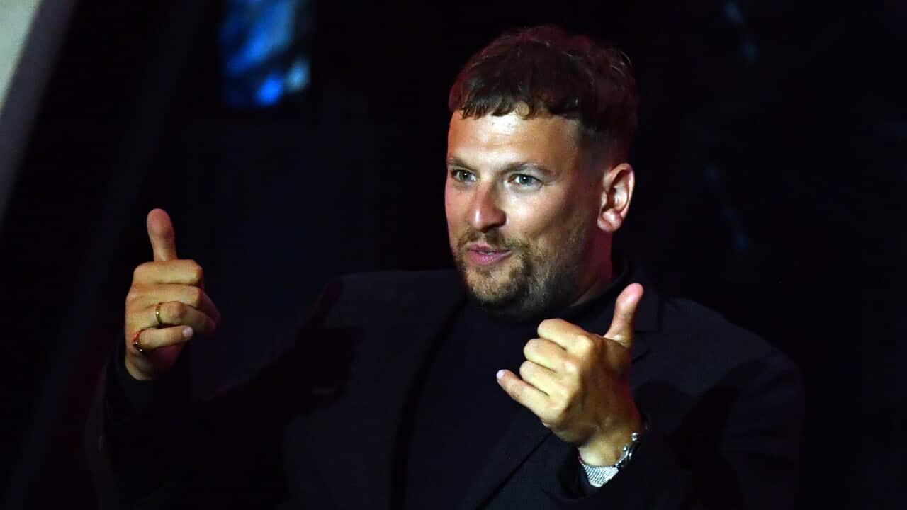 A man gestures and smiles