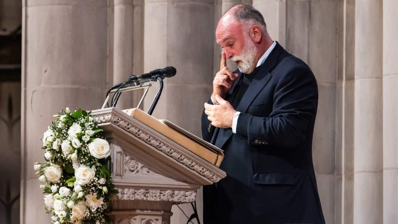 A man tears up at a funeral service.