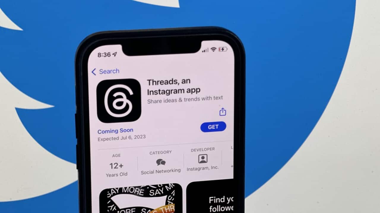 An image of a smartphone that has a page open with details about Threads is set over the Twitter blue bird logo.