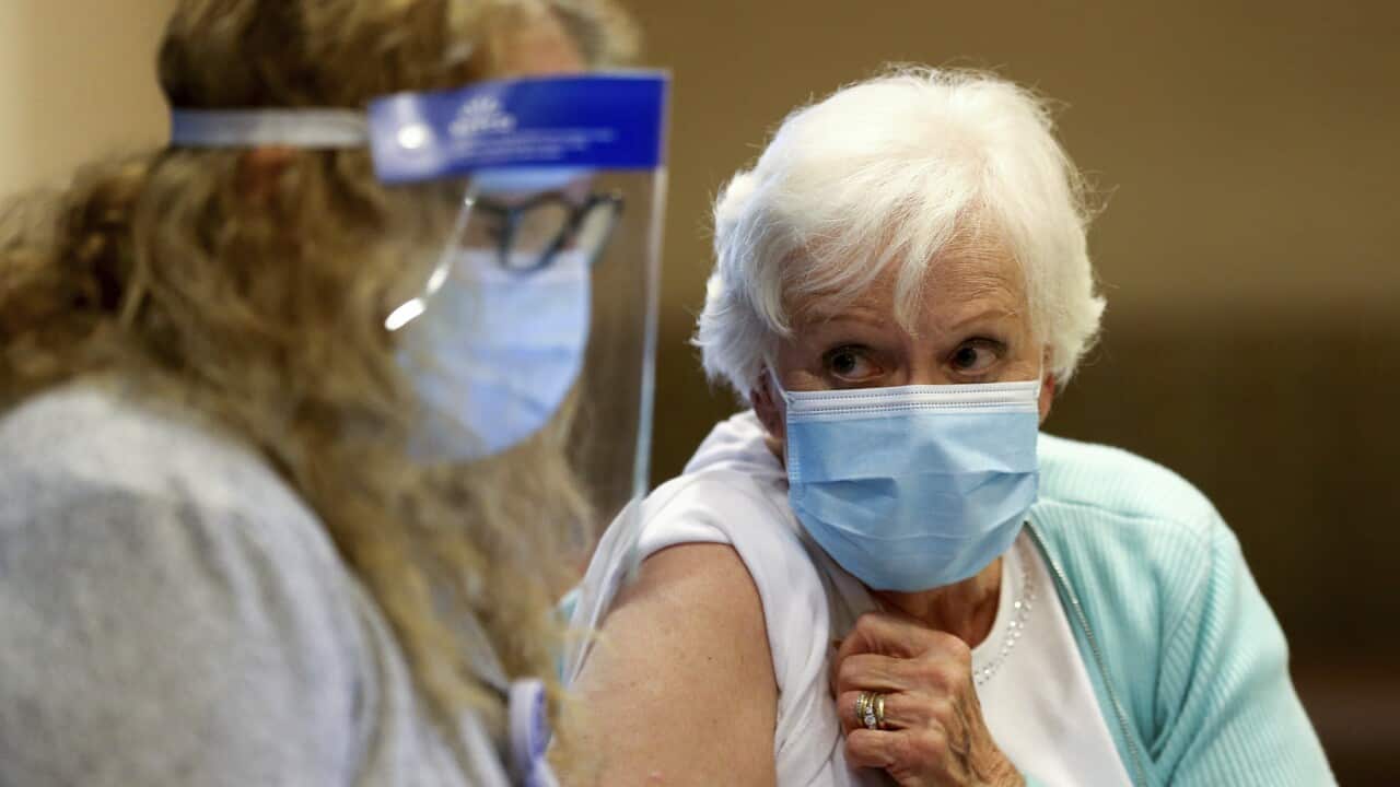 A woman receives her first dose of the COVID-19 vaccine