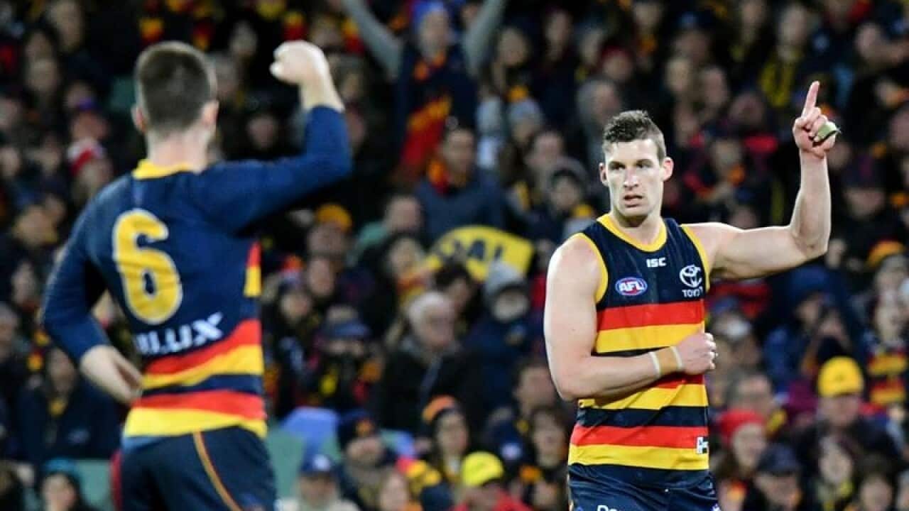 Josh Jenkins of the Crows (right) celebrates after kicking a goal