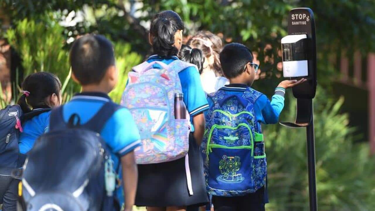 تعدادی از دانشآموزان در حال استفاده از ضدعفونیکننده دست