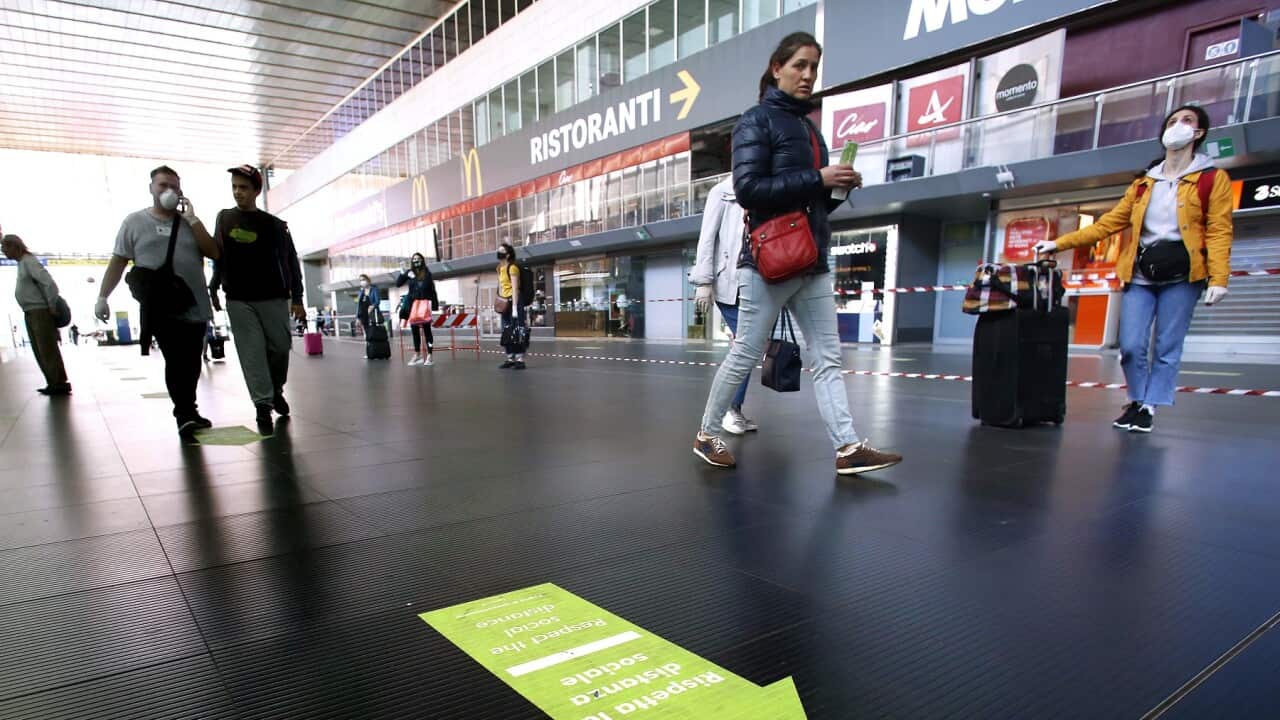 Italians allowed out of lockdown see a 'social distancing' sign at Termini station in Rome