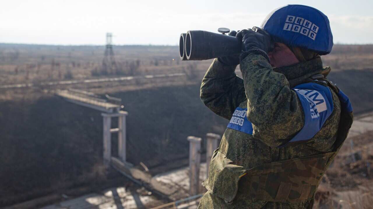 Representative of the Joint Centre for Control and Coordination (JCCC) on ceasefire and stabilization of the demarcation line looks through binoculars