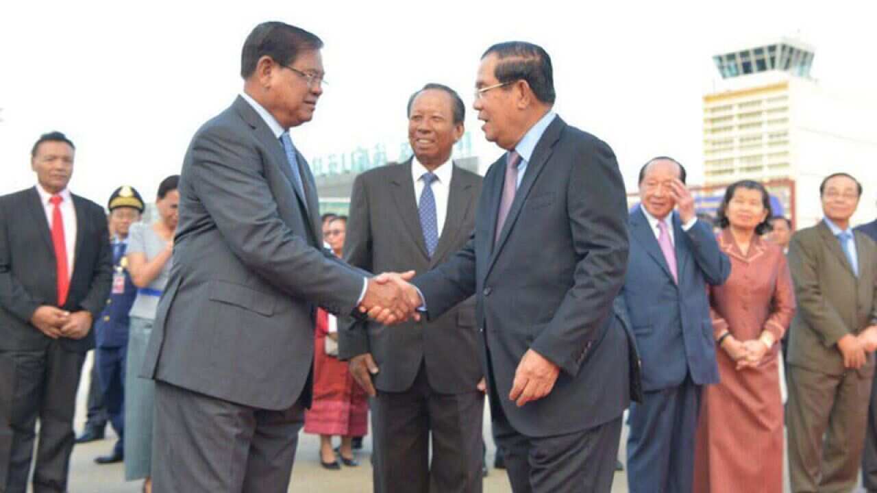 PM Hun Sen shakes hand with deputy PM Sar Kheng