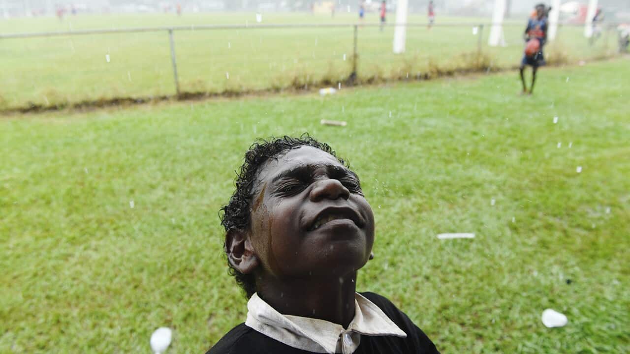 'It Always Rains Before Kick Off' captures a young football fan feeling the rain on his face minutes before kick-off for the Tiwi Islands grand final.