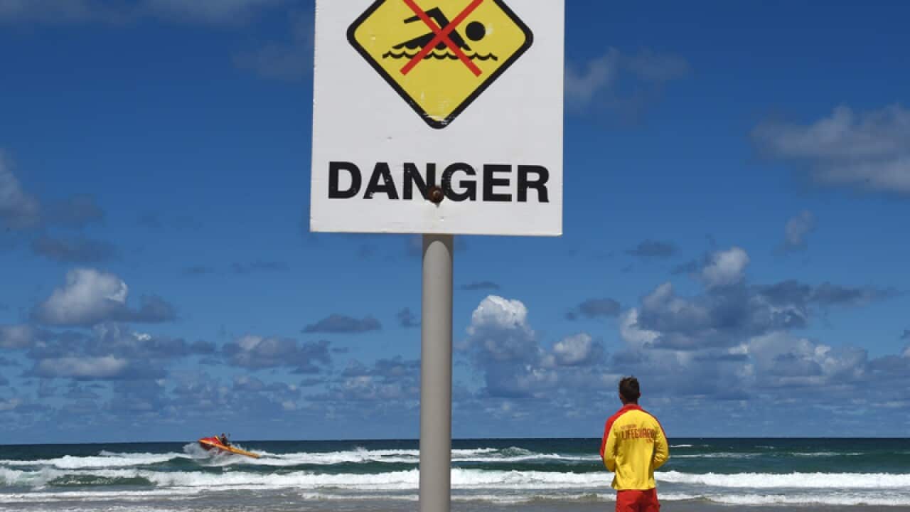 A surf rescue boat searches waters off a Ballina beach
