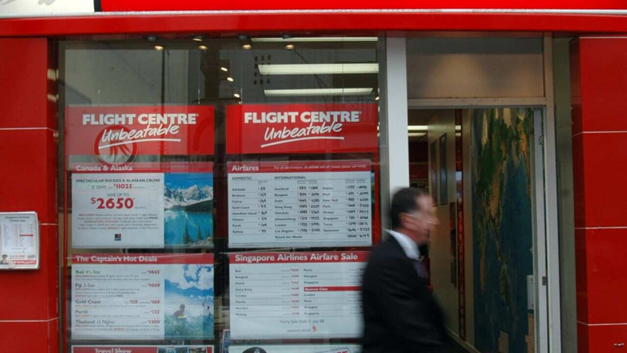 A man walks by travel agent Flight Centre in Melbourne