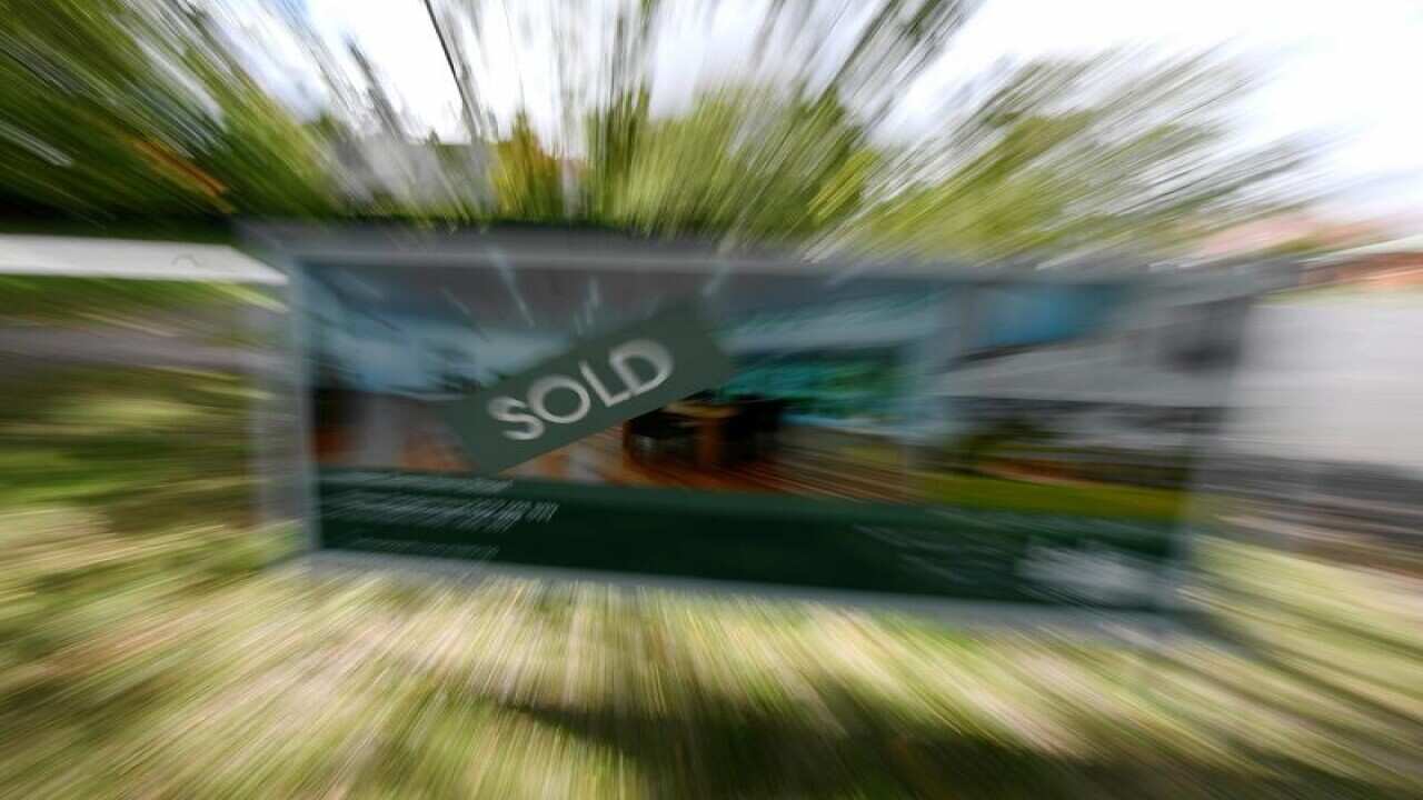 A file image of a real estate advertising board with a Sold sign