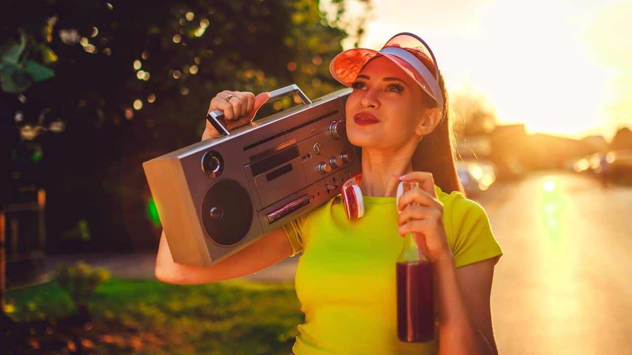 Young Woman In Neon Clothes Carrying A Boombox Radio On The Street