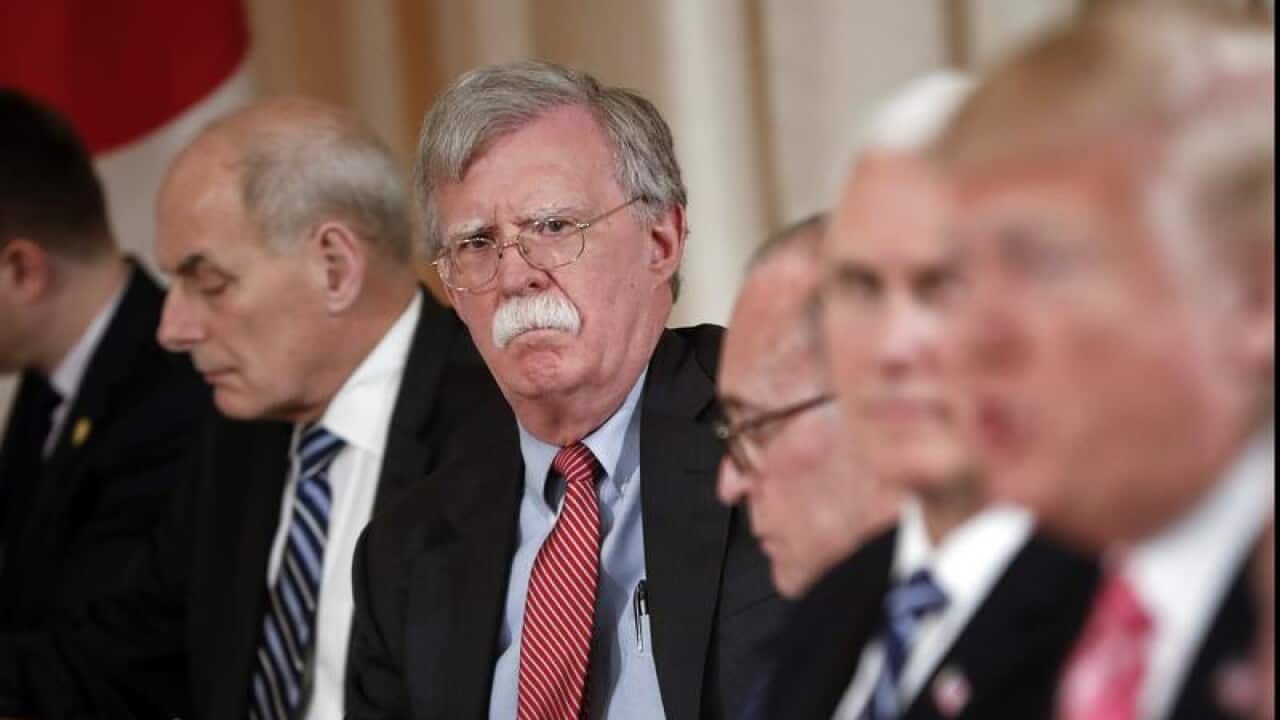 National security adviser John Bolton listens as the president talks