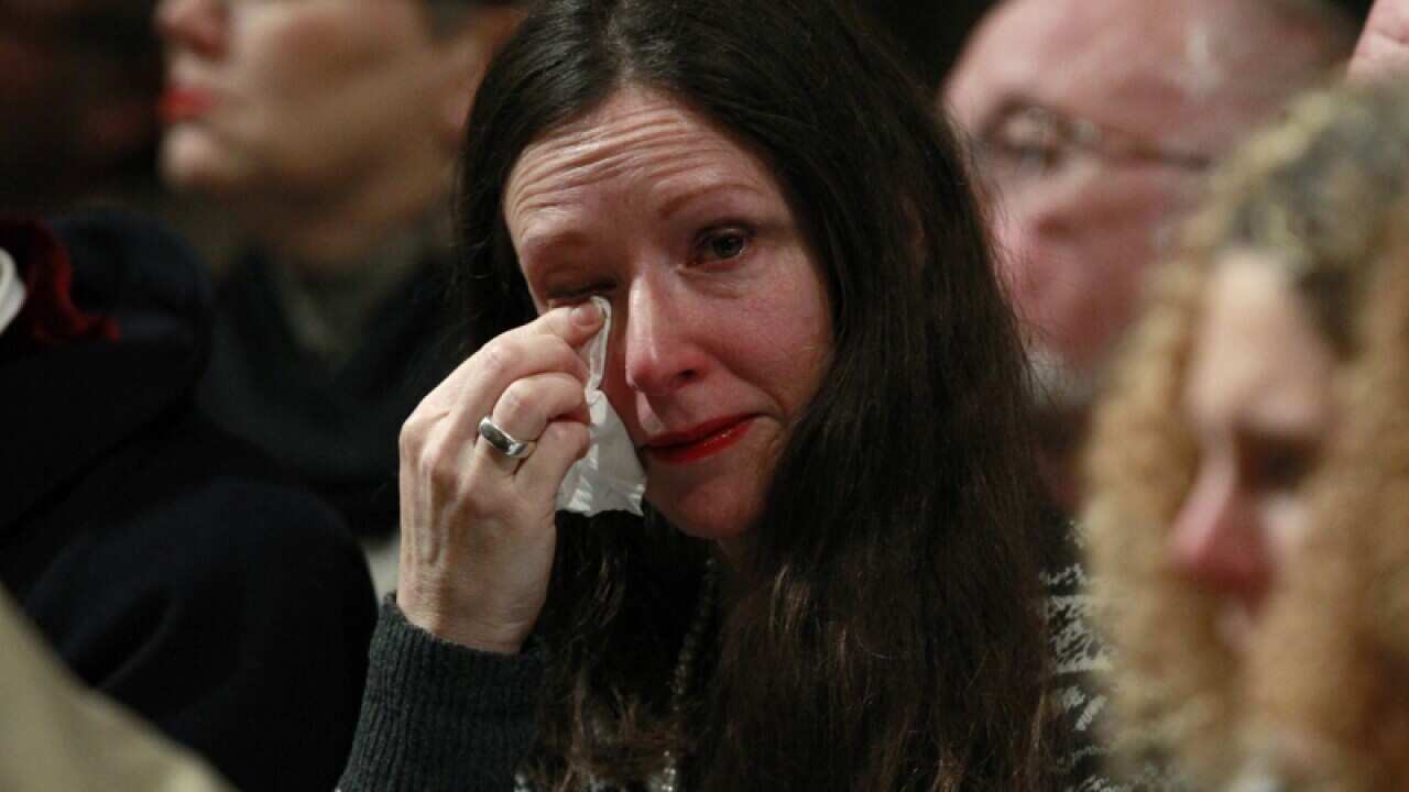 A woman wipes her eye during a service.