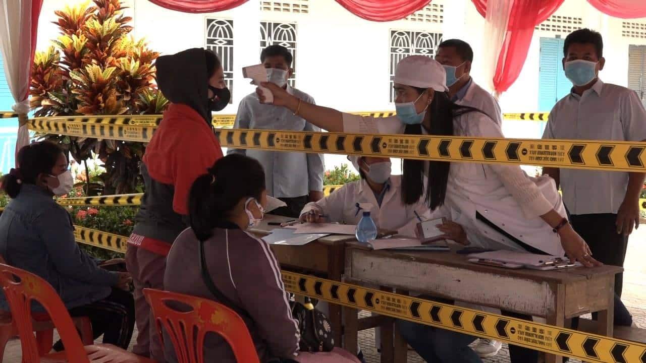 Health official checking temperature on return worker