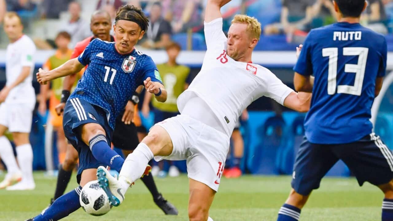 Takashi Usami (11) of Japan is challenged by Kamil Glik of Poland during the second half
