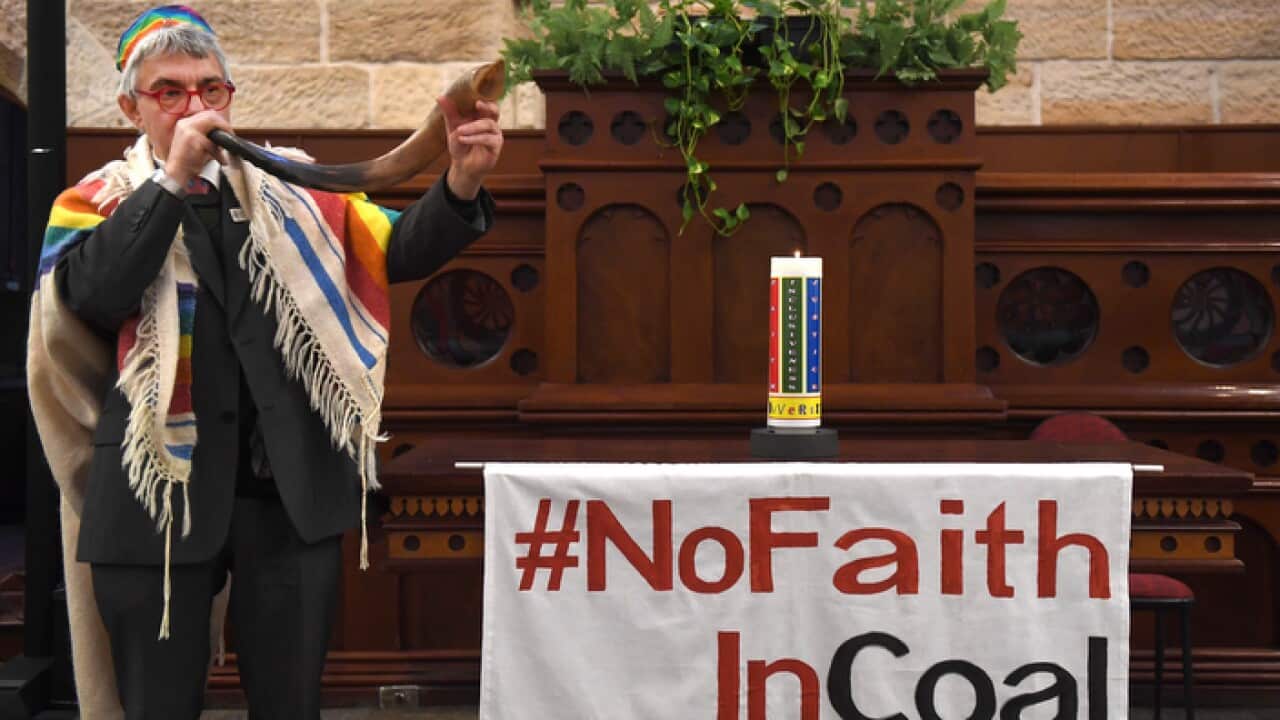 Rabbi Jonathan Keren-Black uses a shofar to sound the end of the era of coal