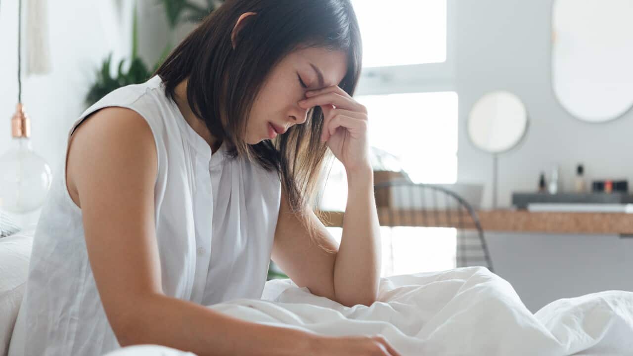Young Woman Suffering Headache In Bed
