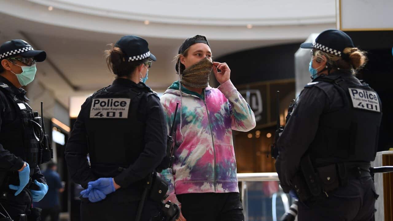 Victoria Police speak to a person inside of Chadstone Shopping Centre following an anti-lockdown protest in Melbourne.