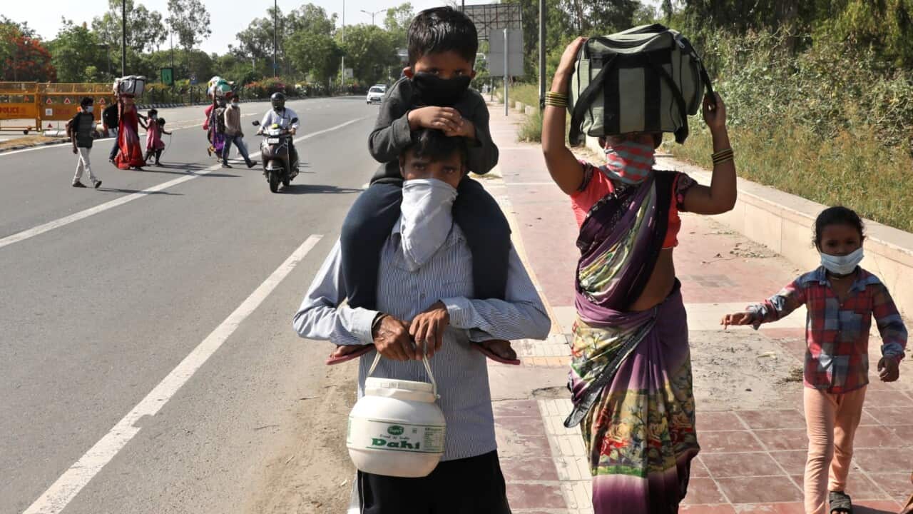 Indian migrant labourers walk on a connecting road to the highway to return to their villages, in New Delhi, India, 12 May 2020.
