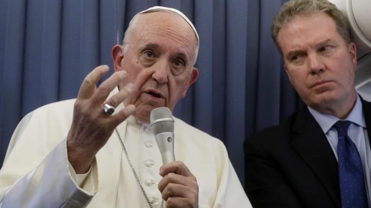 Pope Francis responds to a reporter's question on his plane