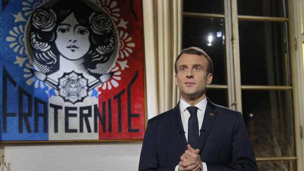French President Emmanuel Macron poses for a photograph after delivering his New Year wishes