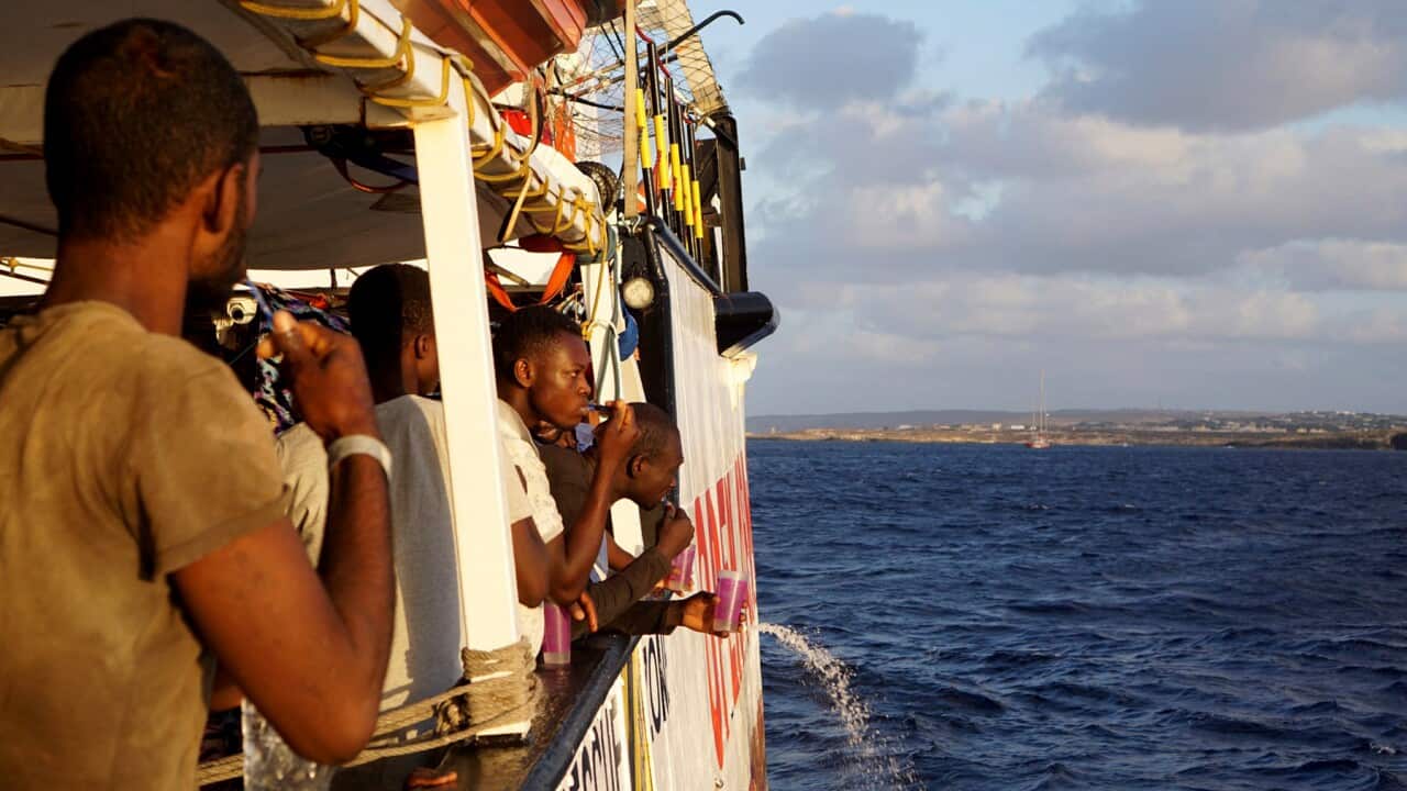 Migrants stand aboard the Open Arms Spanish humanitarian boat (AAP)