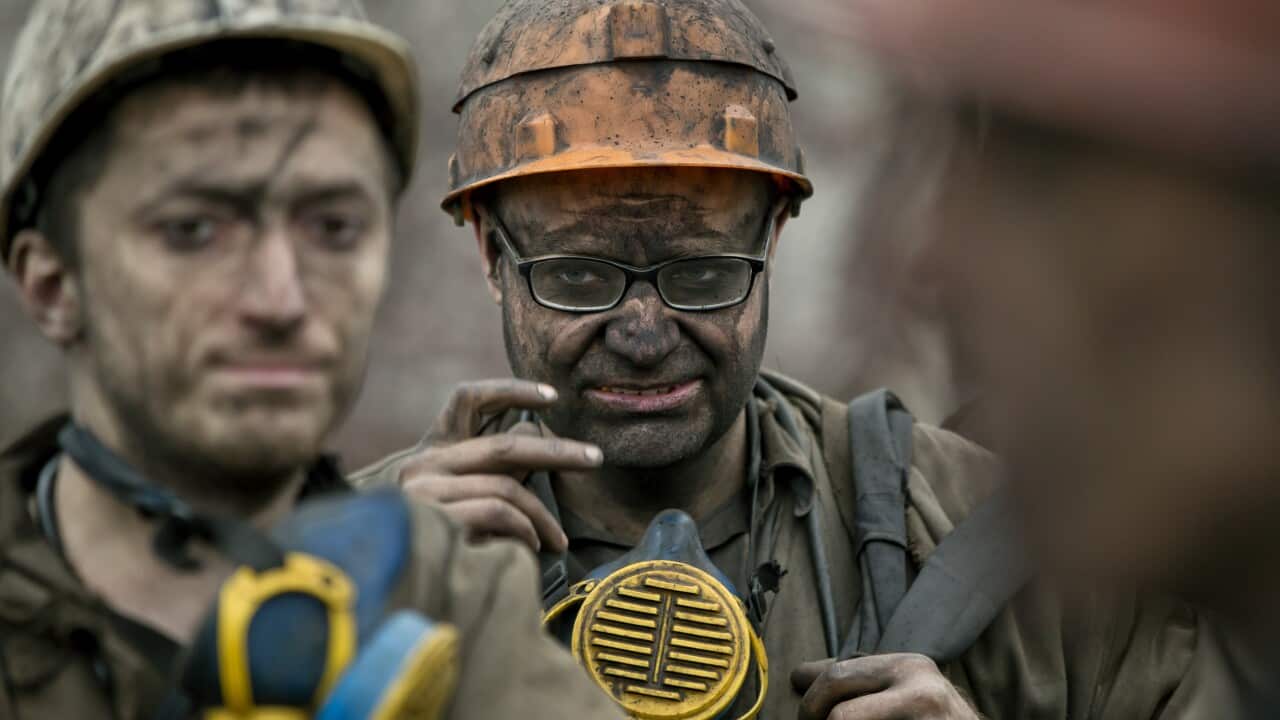Ukrainian coal miners wait for a bus after exiting the underground of the Zasyadko mine in Donetsk, Ukraine, Wednesday, March 4, 2015. (AP Photo/Vadim Ghirda)