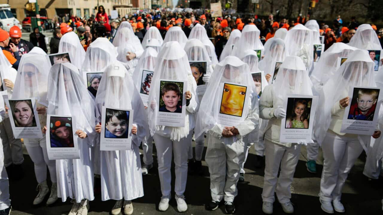 People display portraits of Sandy Hook elementary school shooting victims as they take part in the March for Our Lives in New York