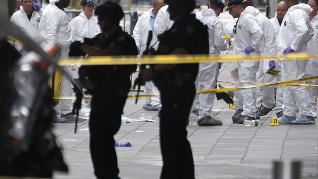 Police officers in protective clothes look over evidence at the scene