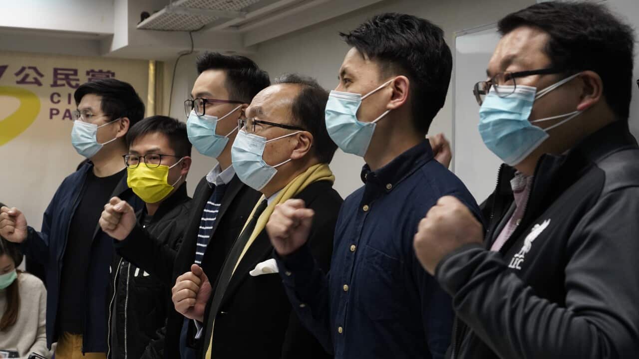 Pro-democratic party members shout slogans in response to the mass arrests at a press conference in Hong Kong.