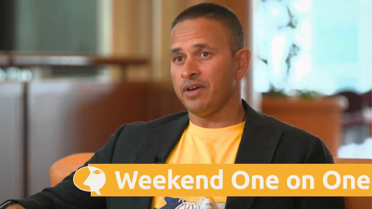 Usman Khawaja in a black suit jacket and yellow T-shirt.