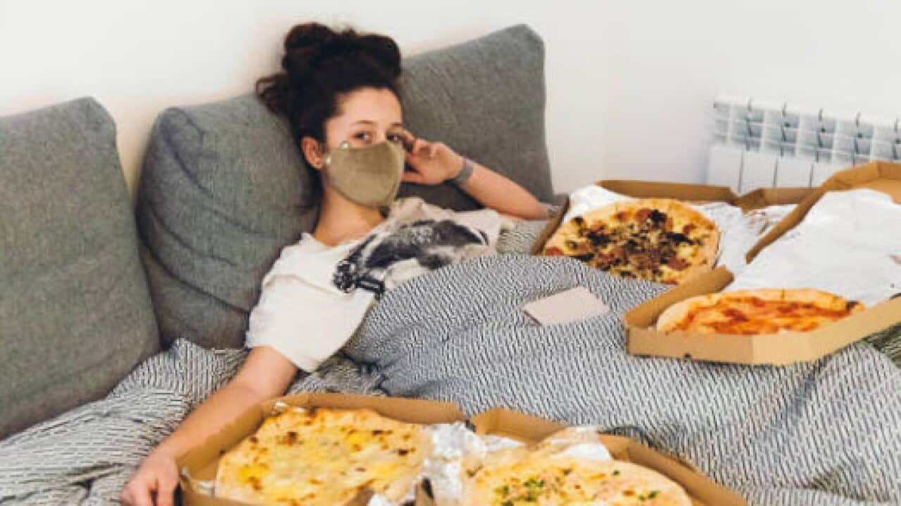 women with a mask and pizza
